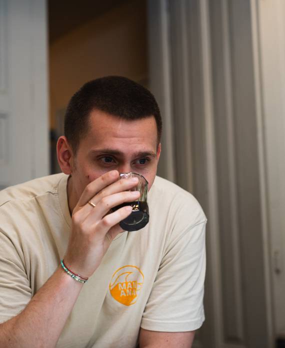 Julius lehnt entspannt an der Bar und probiert einen frisch aufgebrühten Filterkaffee im MANANA