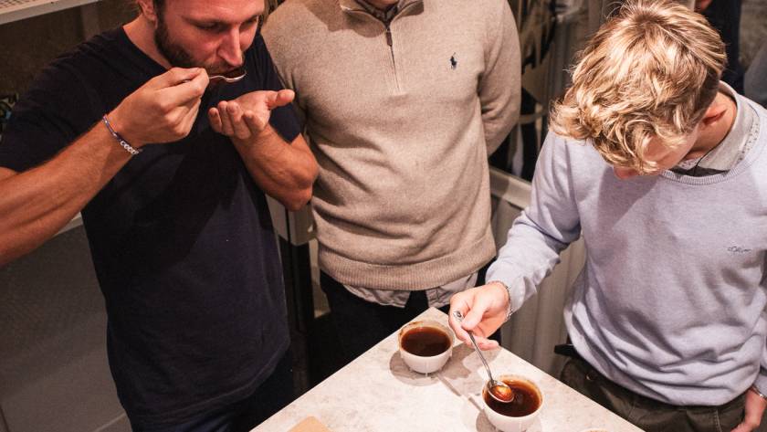 Cupping bei MANANA: Drei Baristas verkosten Omni Roast Röstproben an der Bar, um Geschmack und Balance für verschiedene Brühmethoden zu beurteilen.