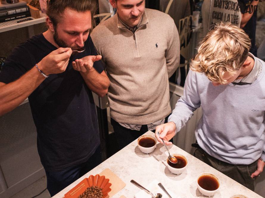 Cupping bei MANANA: Drei Baristas verkosten Omni Roast Röstproben an der Bar, um Geschmack und Balance für verschiedene Brühmethoden zu beurteilen.