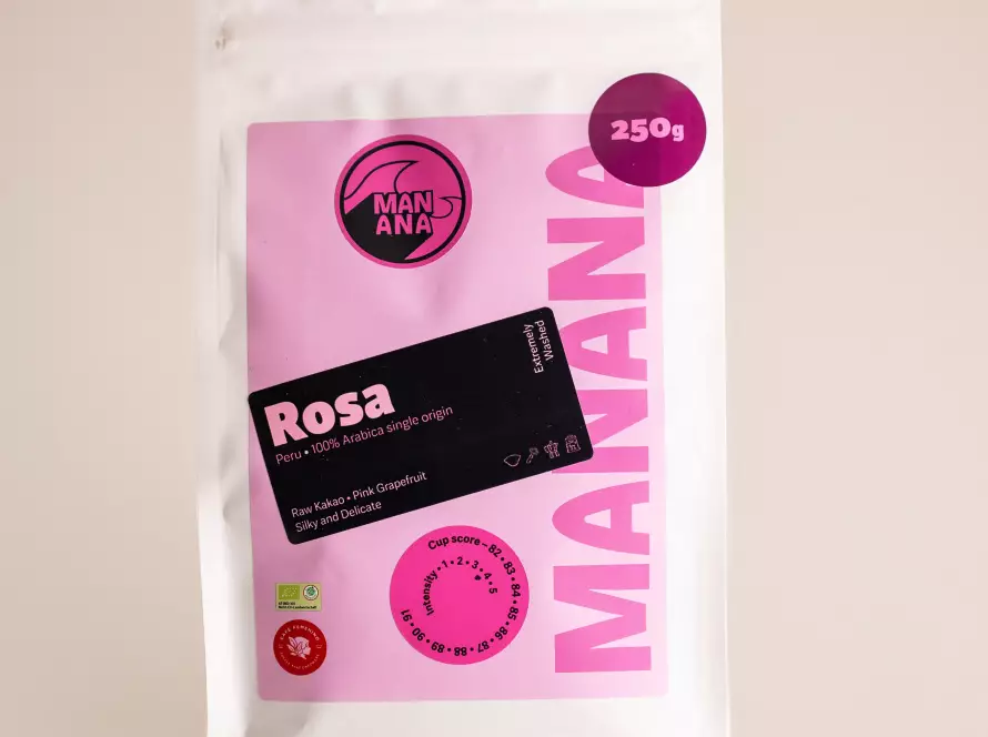 Kaffeetüte von MANANA Coffee mit Rosa 100 Prozent Arabica Kaffeebohnen aus Peru, frontal fotografiert vor hellem, einheitlichem Hintergrund