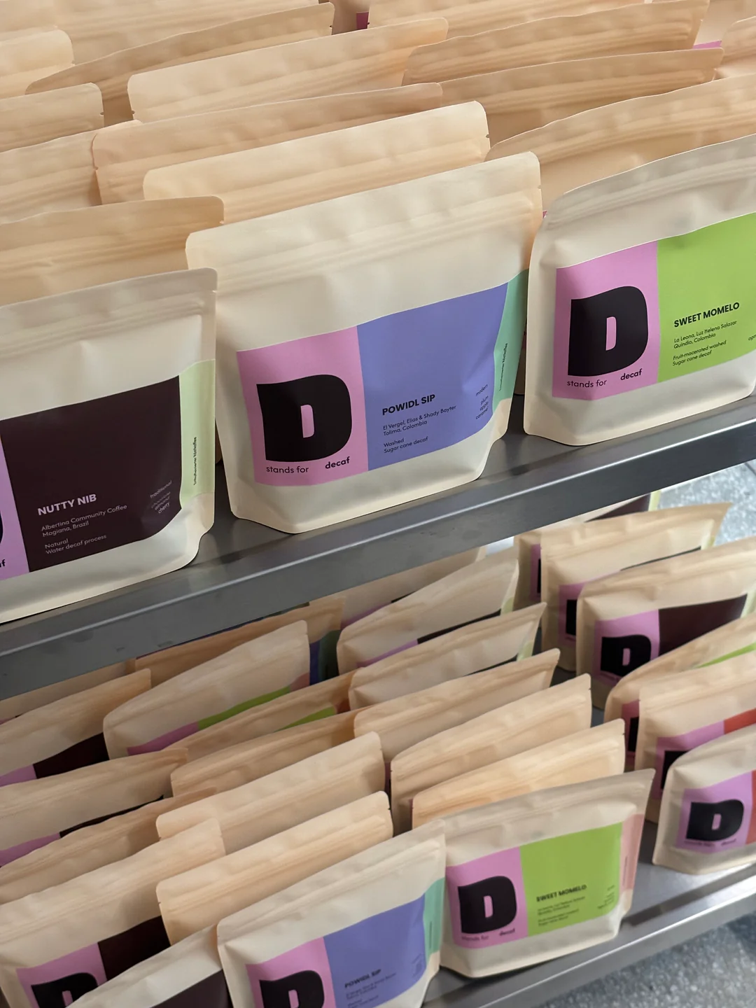 Verschiedene Decaf-Kaffeesäcke von D stands for decaf im Regal des MANANA Cafés in Wien Währing.