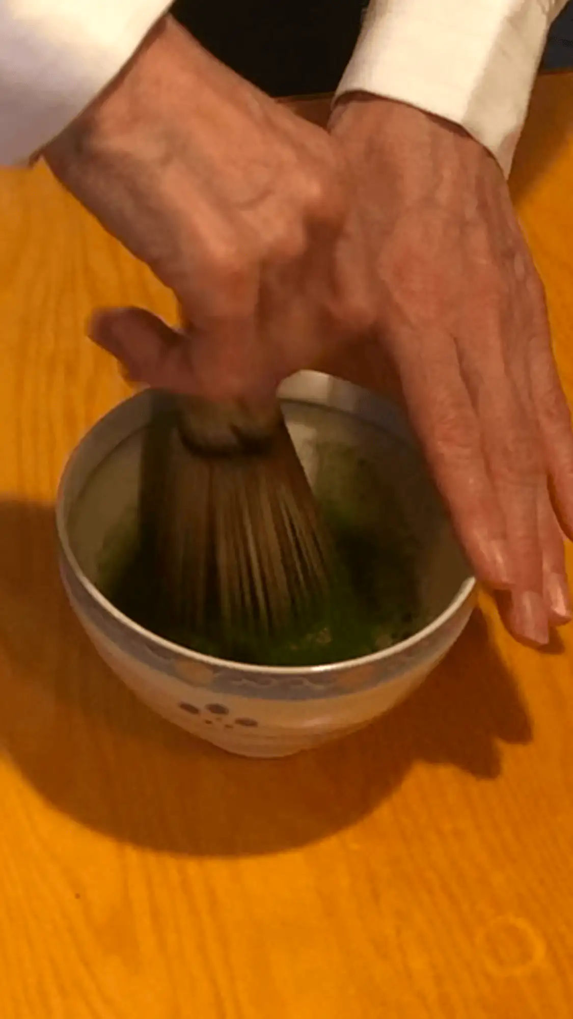 Matcha Zubereitung beim Matcha Tee Workshop Wien im MANANA cafẽ mit Bambusbesen in einer Schale.