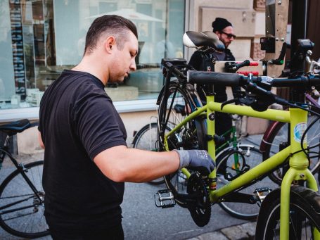 Daniel Cabaj von der mobilen Radwerkstatt wartet ein grünes Fahrrad beim Event vor dem MANANA cafẽ in Währing.