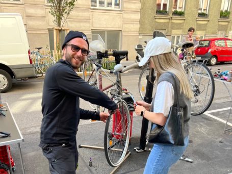 Dirk von MANANA und eine Teilnehmerin reparieren ein Fahrrad beim Event vor dem MANANA cafẽ.